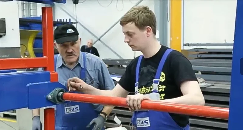 Close up of red crank handle transmission shaft and bearings on a retractable rack